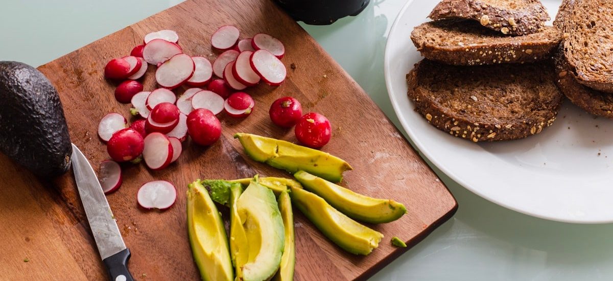 banana fruit and bread on brown wooden chopping board