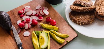 banana fruit and bread on brown wooden chopping board