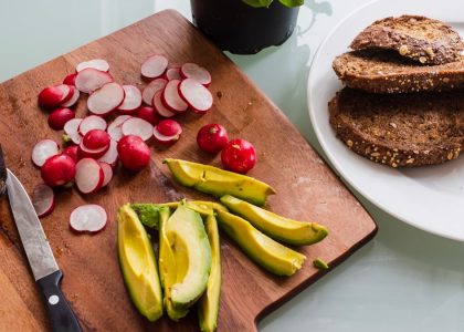 banana fruit and bread on brown wooden chopping board